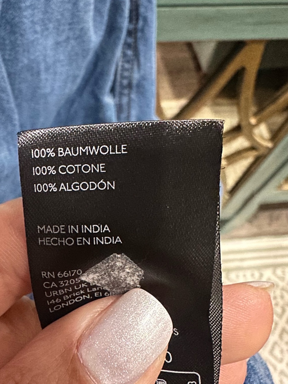Anthropologie black care label on blue denim garment